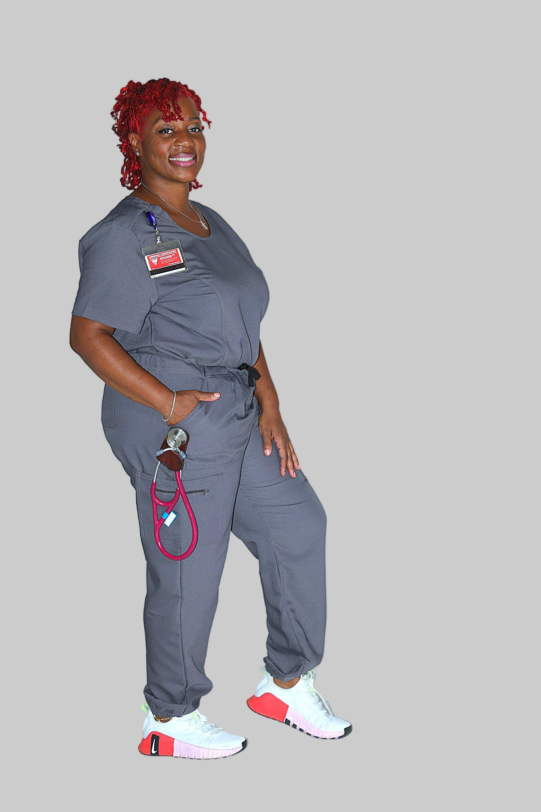 Model walking in grey Valmasi scrub pants, showcasing comfort, flexibility, and professional fit.