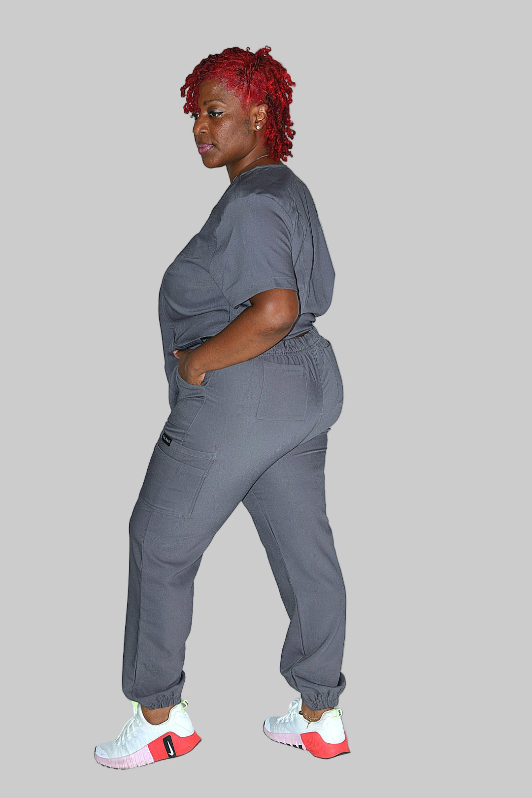 Side profile of grey scrub pants highlighting curve-friendly design and tailored fit.