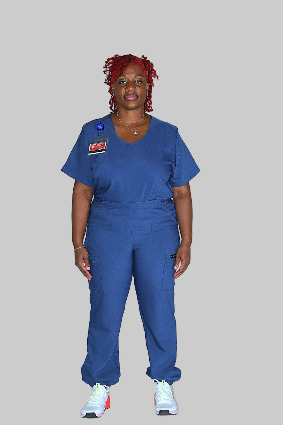 Professional women’s blue scrub top with comfortable stretch fabric and front pockets.