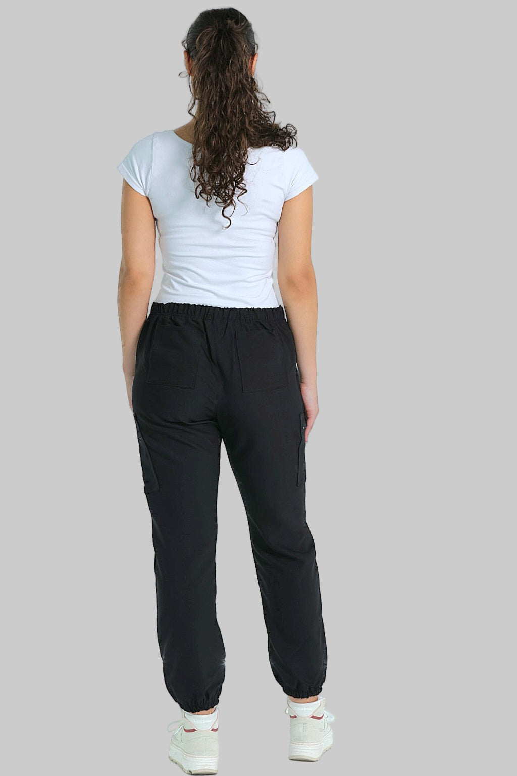 Back view of black jogger scrubs with contoured seams, cuffed ankles, and a comfortable high-rise waistband.