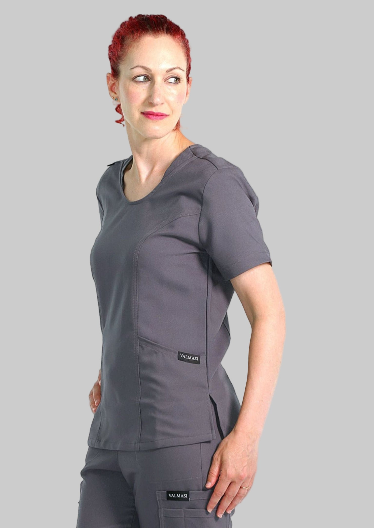 Grey scrub top for women featuring a relaxed fit, round neckline, and dual front pockets.